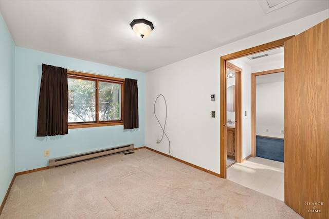 spare room with a baseboard heating unit, light carpet, and baseboards