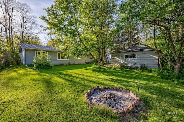 view of green lawn with a fire pit