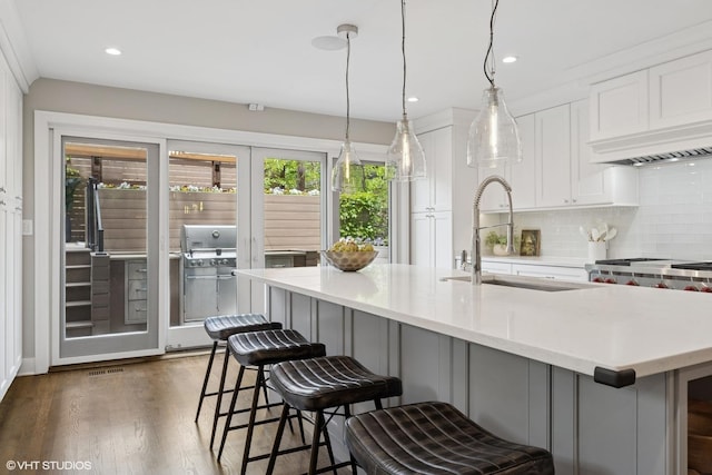 1048 W Webster Ave, Chicago, IL 60614 - kitchen featuring a sink, backsplash, white cabinetry, a breakfast bar, and recessed lighting