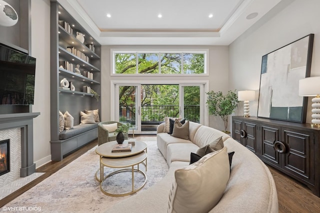 1048 W Webster Ave, Chicago, IL 60614 - living room featuring wood finished floors, a tiled fireplace, a tray ceiling, recessed lighting, and ornamental molding