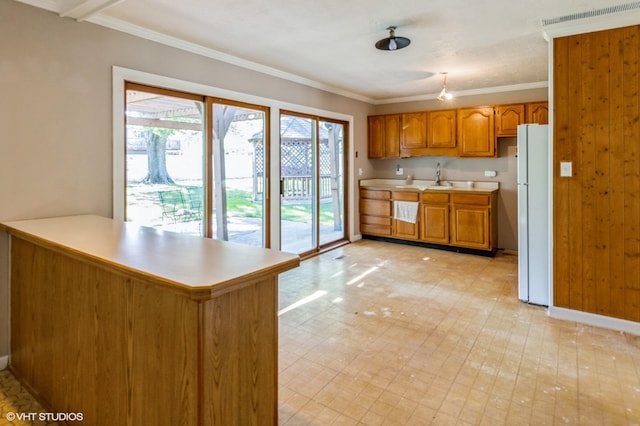 1179 Pegwood Dr, Elgin, IL 60120 - kitchen featuring freestanding refrigerator, light countertops, brown cabinetry, ornamental molding, and a peninsula