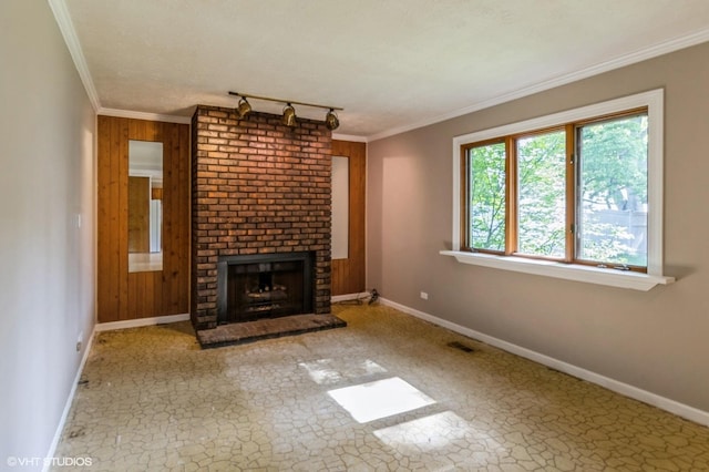1179 Pegwood Dr, Elgin, IL 60120 - unfurnished living room featuring baseboards, a brick fireplace, track lighting, crown molding, and wooden walls