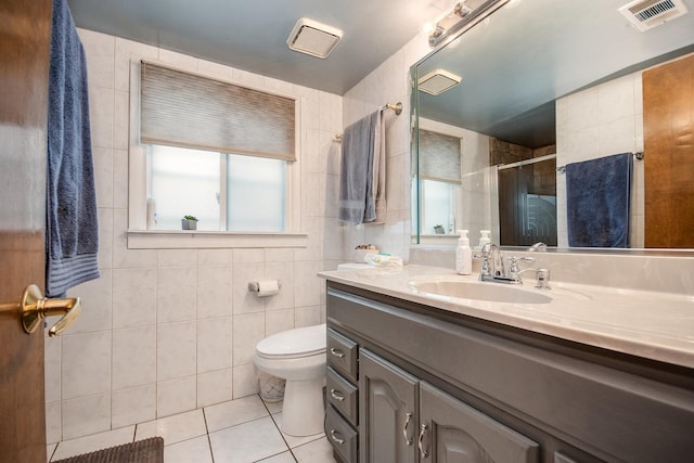 full bath with tile patterned flooring, a shower stall, tile walls, toilet, and vanity