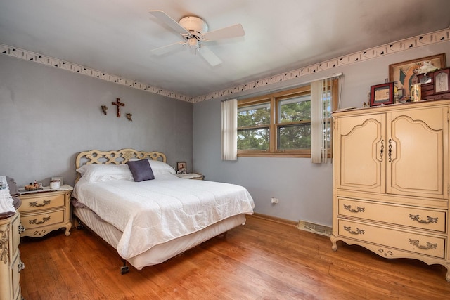 bedroom featuring light wood-style flooring, baseboards, and a ceiling fan