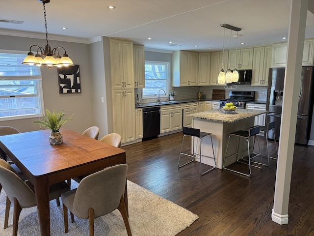 11 S Roberts Rd, Inverness, IL 60067 - kitchen featuring appliances with stainless steel finishes, ornamental molding, dark wood-type flooring, decorative backsplash, and a center island