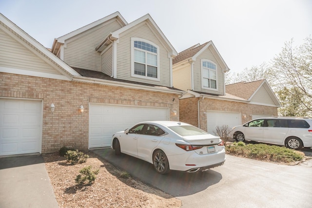view of front of property with brick siding, asphalt driveway, and a garage