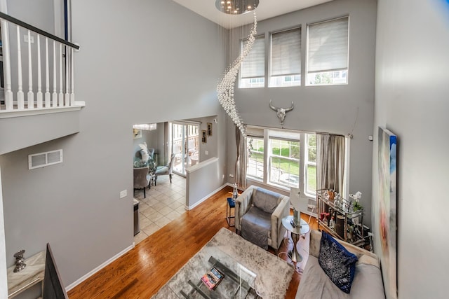 living room featuring a high ceiling, wood finished floors, and baseboards