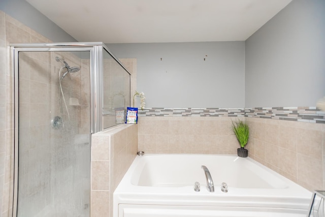 full bathroom with a shower stall and a bath