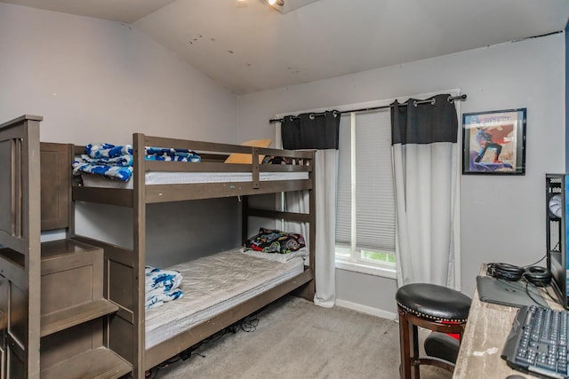 bedroom with light colored carpet, lofted ceiling, and baseboards