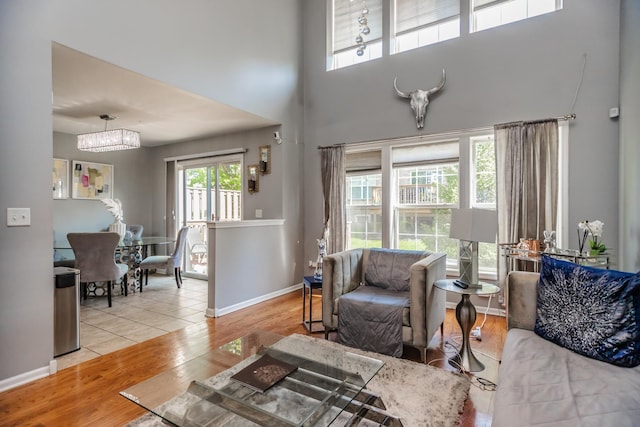 living room with wood finished floors, a towering ceiling, and baseboards