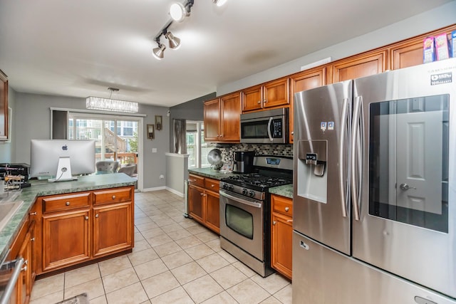 kitchen featuring appliances with stainless steel finishes, brown cabinetry, light tile patterned floors, backsplash, and dark countertops