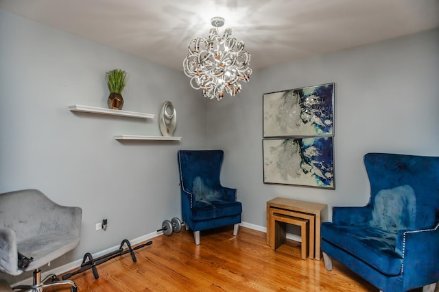 living area with a chandelier, wood finished floors, and baseboards