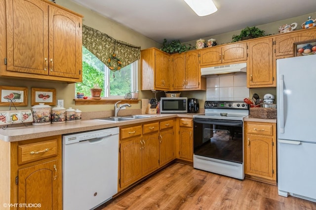 1722 John St, Yorkville, IL 60560 - kitchen with white appliances, under cabinet range hood, a sink, light countertops, and light wood-style flooring