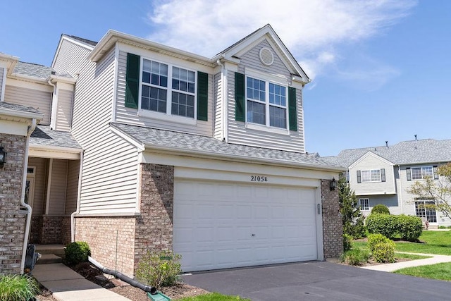 view of front of home with brick siding, an attached garage, and concrete driveway