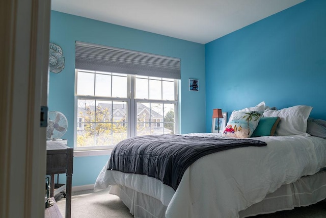 bedroom featuring multiple windows, carpet, and baseboards