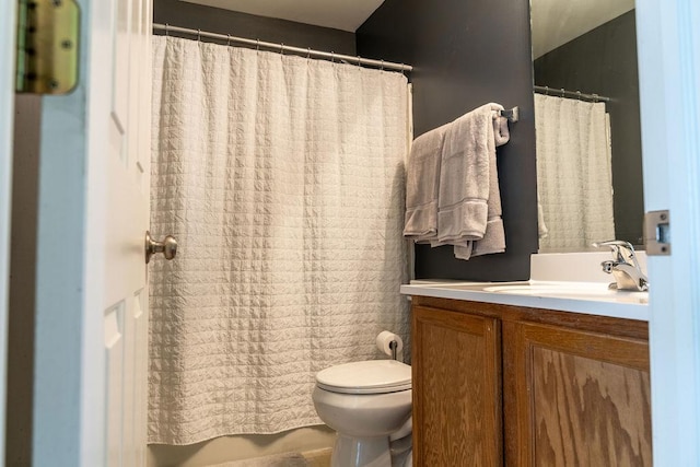 bathroom with toilet, vanity, and curtained shower