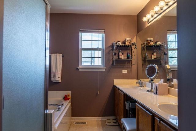 bathroom with double vanity, a garden tub, and baseboards