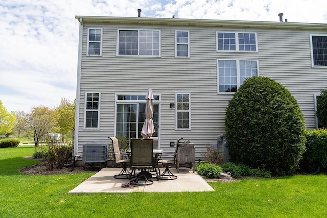 back of house with central AC, a patio area, and a lawn