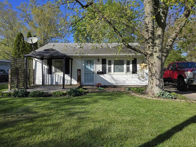view of front facade with a front yard and roof with shingles