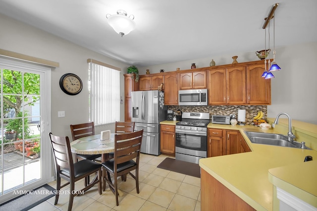 1677 Brightwood Pl Unit 8B, Aurora, IL 60506 - kitchen featuring appliances with stainless steel finishes, a sink, tasteful backsplash, light countertops, and brown cabinets
