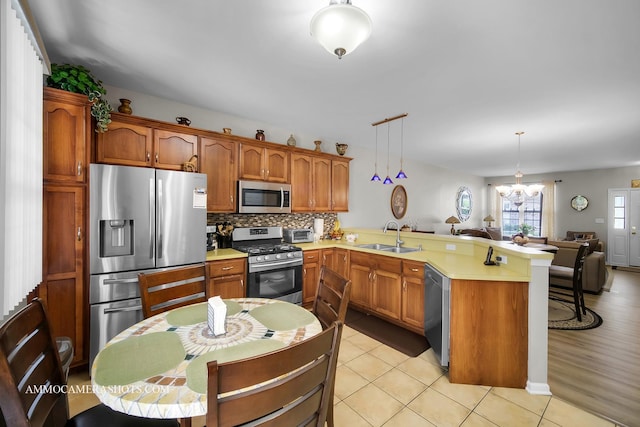 1677 Brightwood Pl Unit 8B, Aurora, IL 60506 - kitchen featuring stainless steel appliances, a peninsula, a sink, open floor plan, and light countertops