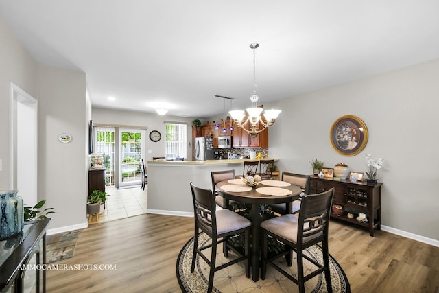 1677 Brightwood Pl Unit 8B, Aurora, IL 60506 - dining space featuring a chandelier, light wood finished floors, and baseboards