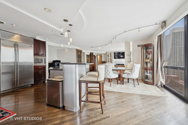 1122 N Clark St Unit 3301-10, Chicago, IL 60610 - kitchen with built in appliances, a kitchen breakfast bar, dark wood-style floors, hanging light fixtures, and a center island