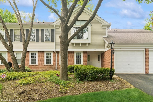 708 Newgate Ln Unit A, Prospect Heights, IL 60070 - townhome / multi-family property featuring a garage, brick siding, and asphalt driveway