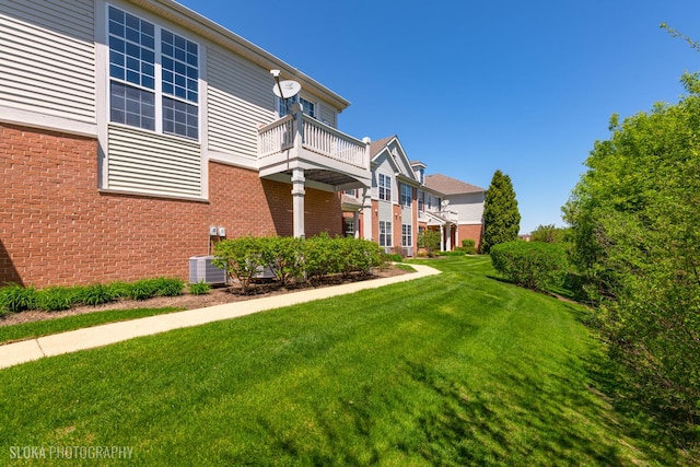 2253 Concord Dr, Mchenry, IL 60050 - view of home's exterior featuring a balcony, brick siding, a yard, and central AC