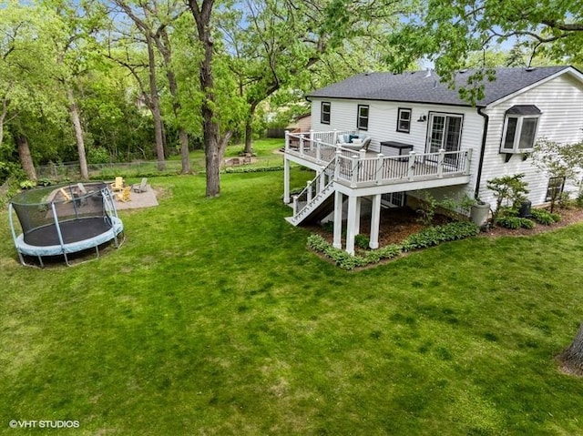 1811 Maplewood Ct, Lindenhurst, IL 60046 - view of grassy yard with a wooden deck, a trampoline, an outdoor fire pit, stairway, and view of scattered trees