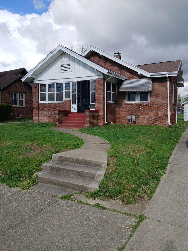929 Garfield Pl, Danville, IL 61832 - view of front facade featuring brick siding, a front lawn, and a chimney