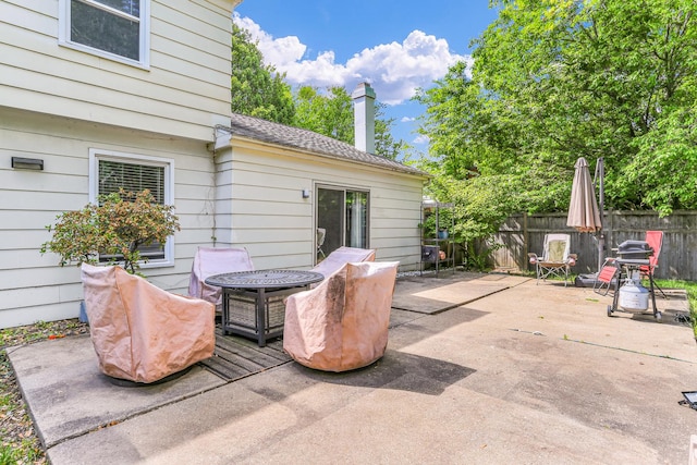 view of patio with fence and a fire pit