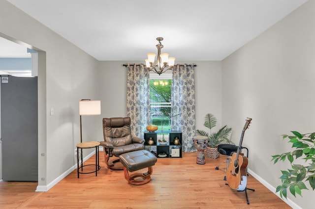 sitting room with a chandelier, wood finished floors, and baseboards