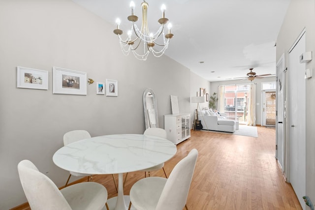dining area featuring light wood-style flooring, a chandelier, and ceiling fan