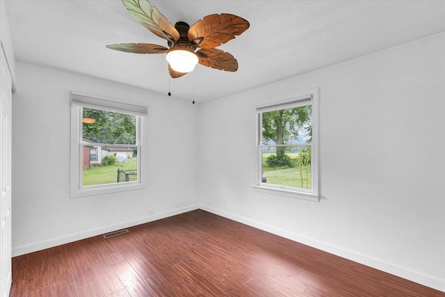 3408 E University Ave, Urbana, IL 61802 - spare room featuring dark wood-style flooring and a ceiling fan