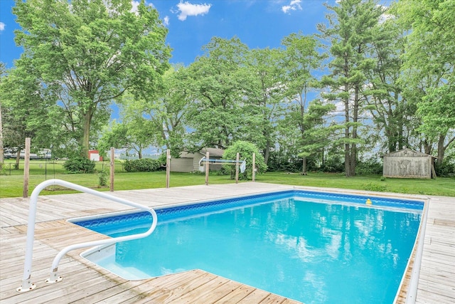 3408 E University Ave, Urbana, IL 61802 - outdoor pool with a lawn, a wooden deck, an outdoor structure, and view of wooded area