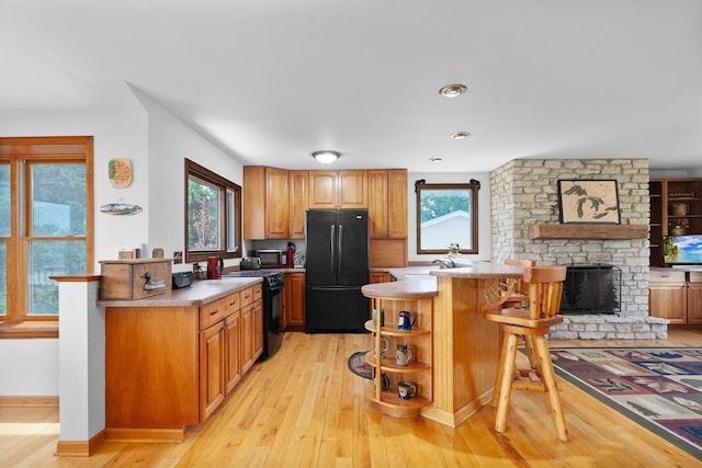 46 Feece Dr, Batavia, IL 60510 - kitchen featuring black appliances, light wood-style floors, a breakfast bar, and open shelves
