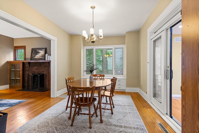 711 W Iowa St, Urbana, IL 61801 - dining room featuring a chandelier, light wood finished floors, a fireplace, and baseboards