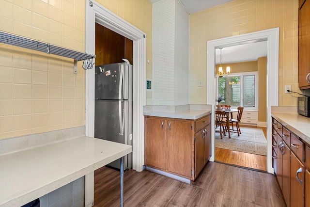 711 W Iowa St, Urbana, IL 61801 - kitchen with freestanding refrigerator, dark wood-type flooring, brown cabinetry, a chandelier, and light countertops