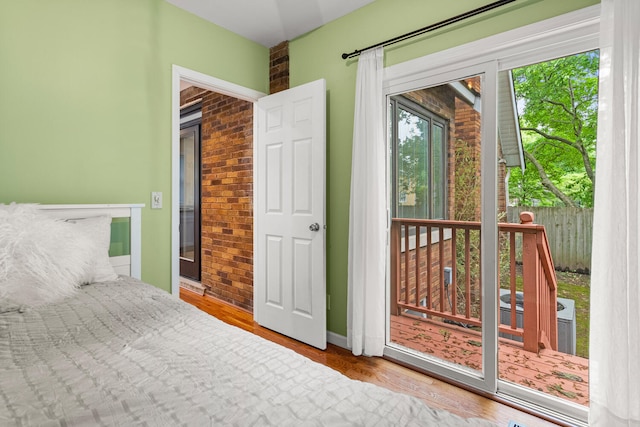 711 W Iowa St, Urbana, IL 61801 - bedroom with wood finished floors, baseboards, and brick wall