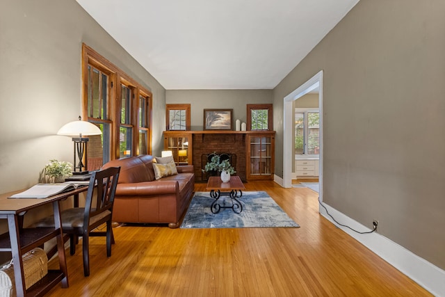 711 W Iowa St, Urbana, IL 61801 - living room with light wood-style floors, a brick fireplace, and baseboards