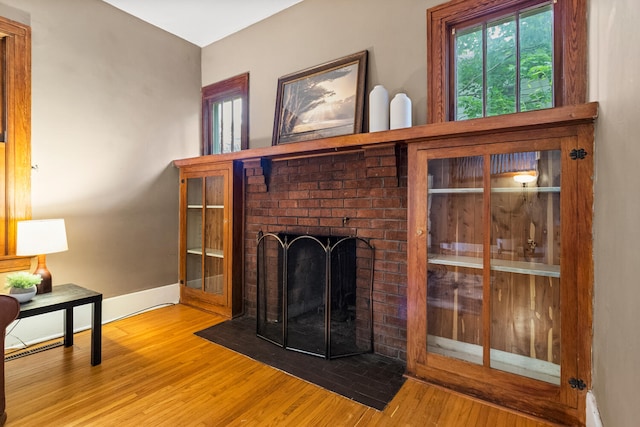 711 W Iowa St, Urbana, IL 61801 - living area featuring wood finished floors, a brick fireplace, and baseboards