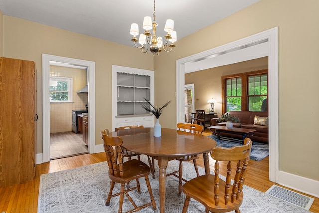 711 W Iowa St, Urbana, IL 61801 - dining room featuring a chandelier, light wood-style flooring, and baseboards