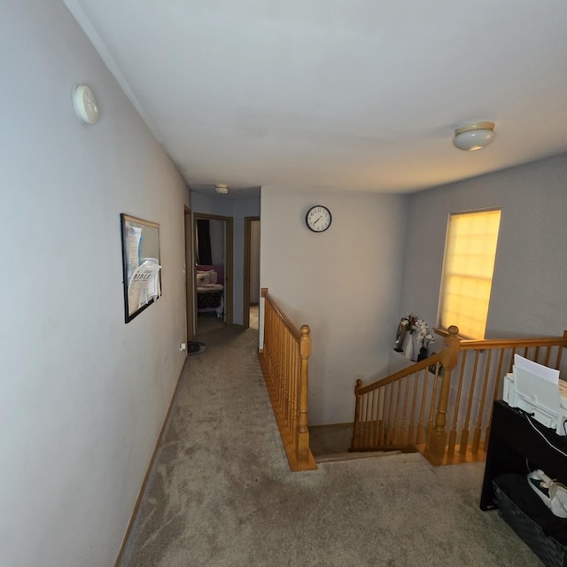 hall with an upstairs landing and carpet