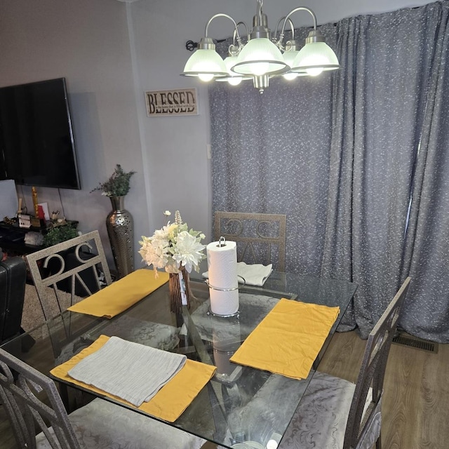 dining area with a chandelier and wood finished floors