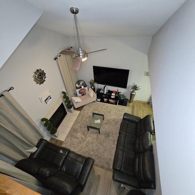 living area with wood finished floors, lofted ceiling, and a fireplace