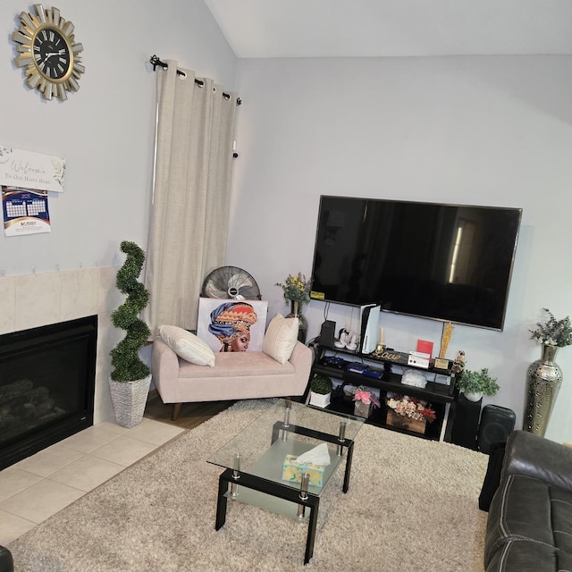 living room featuring lofted ceiling, a tiled fireplace, and tile patterned flooring