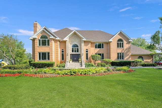 view of front of property with a chimney, a front lawn, and stone siding