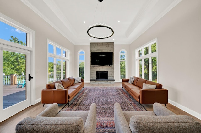 living room with healthy amount of natural light, crown molding, recessed lighting, light wood finished floors, and a high ceiling