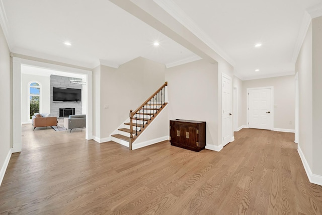corridor with light wood-style floors, stairs, crown molding, baseboards, and recessed lighting